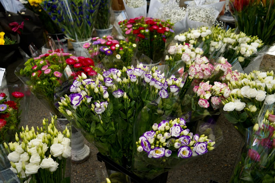 A diverse display of fresh flower bouquets arranged on a dark marble table, featuring a variety of blooms such as purple and white lisianthus, pink and white spray roses, red gerbera daisies, white fr